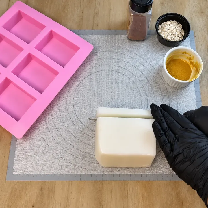 Barra pronta de base glicerinada sendo cortada sobre o tapete de silicone